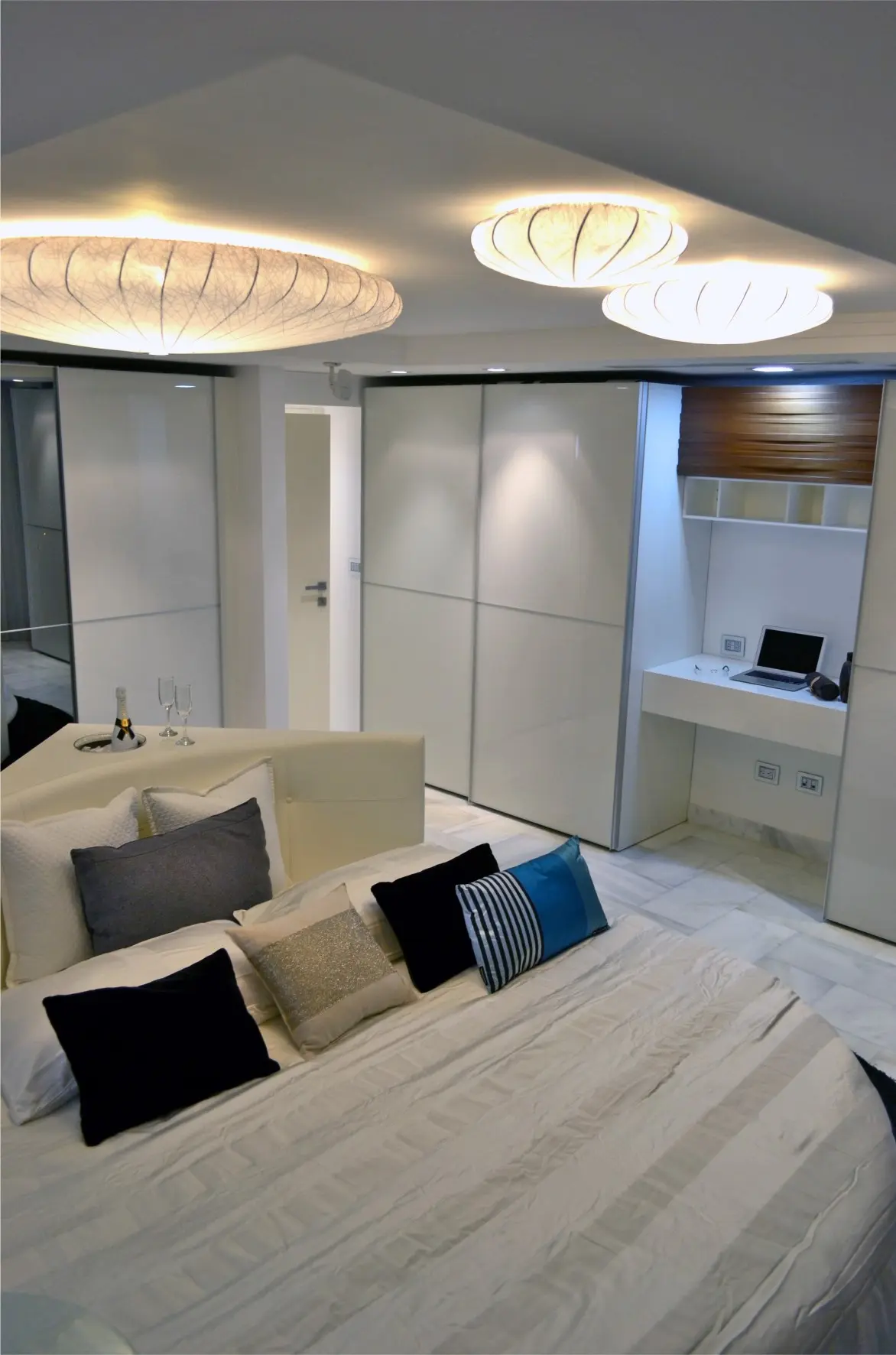 Bed with 3 round lamps and closet