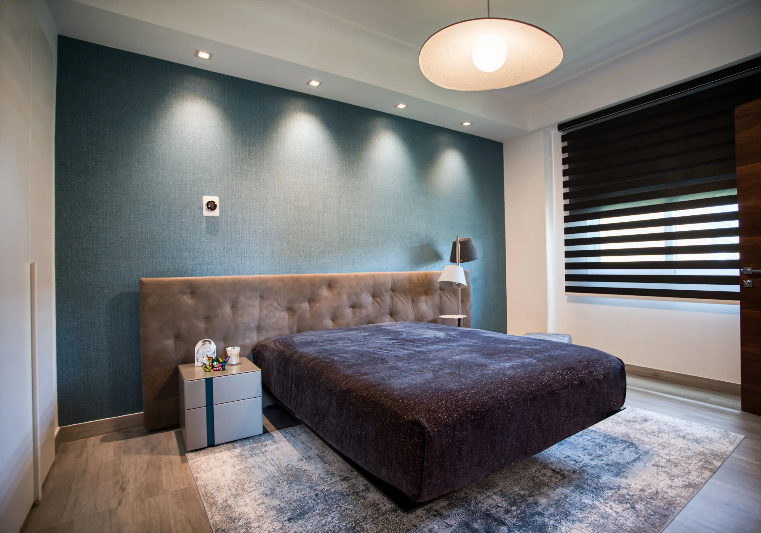 Brown bed with white carpet and blue wall