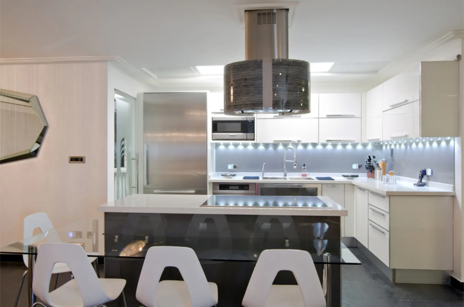 White kitchen with black island and kitchen hood