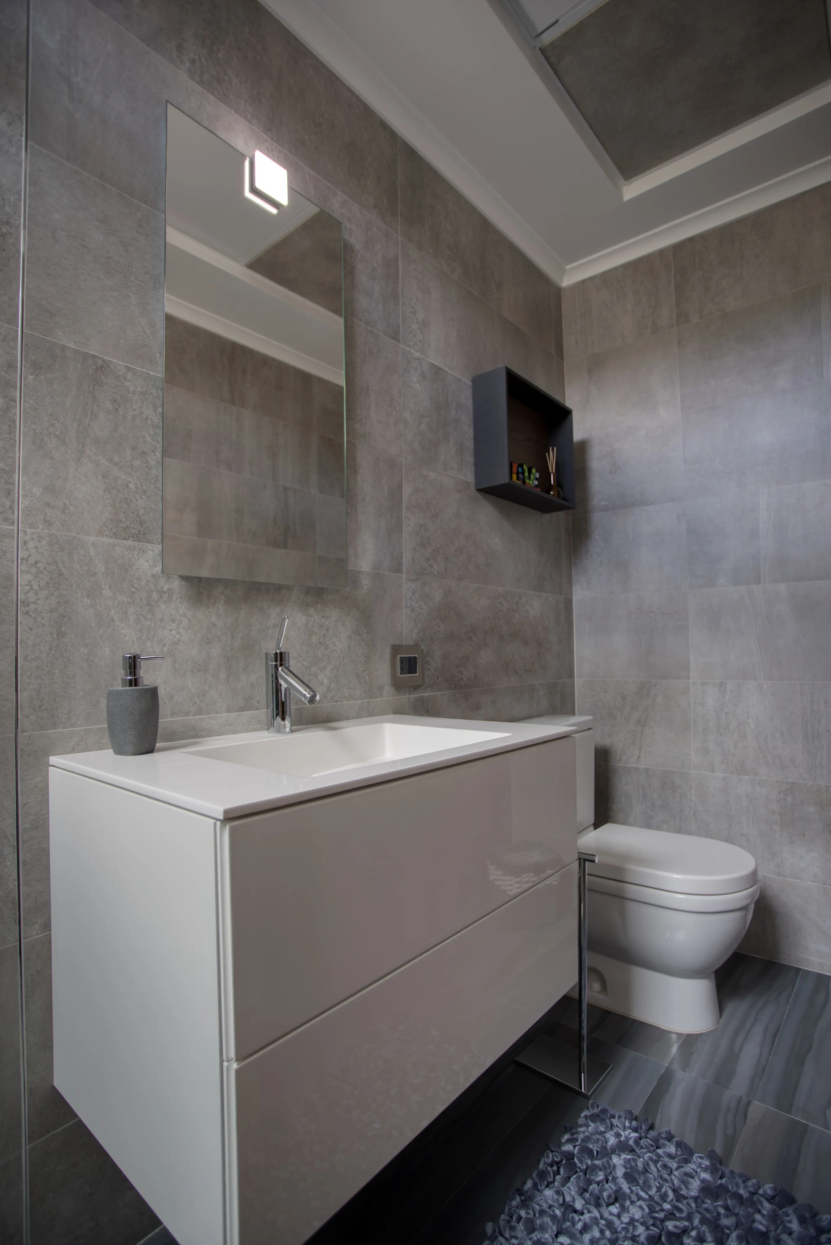 White sink with mirror and gray wall