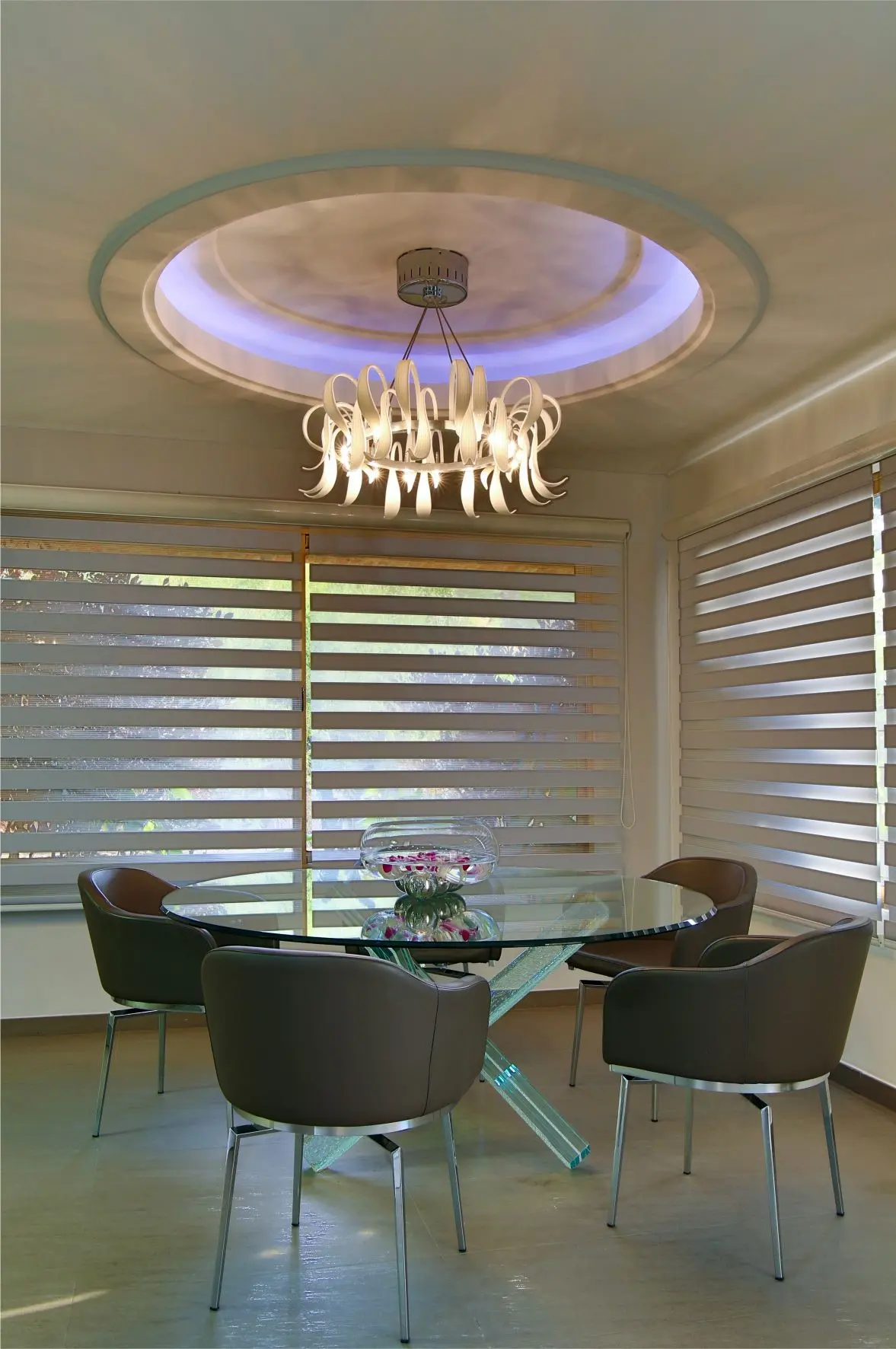 Crystal dining table with brown chairs and crystal lamp