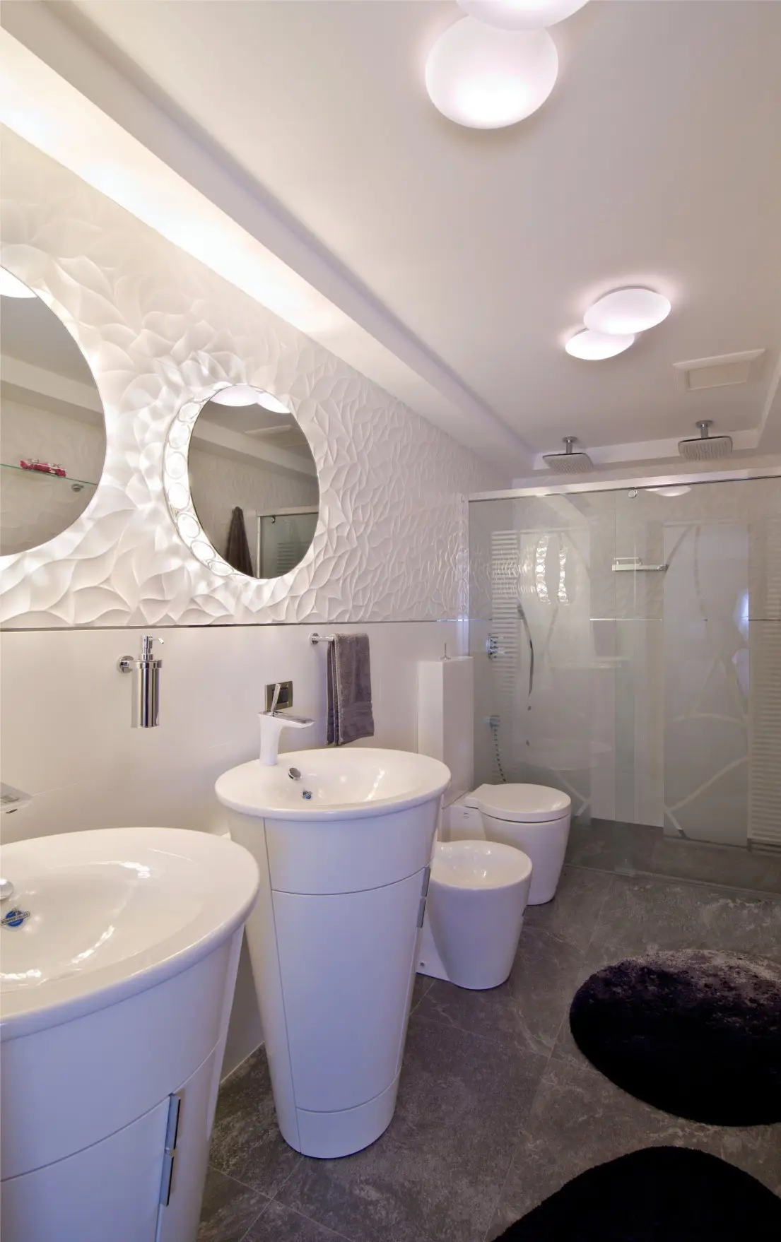 2 sinks with mirrors. Toilet and shower in background