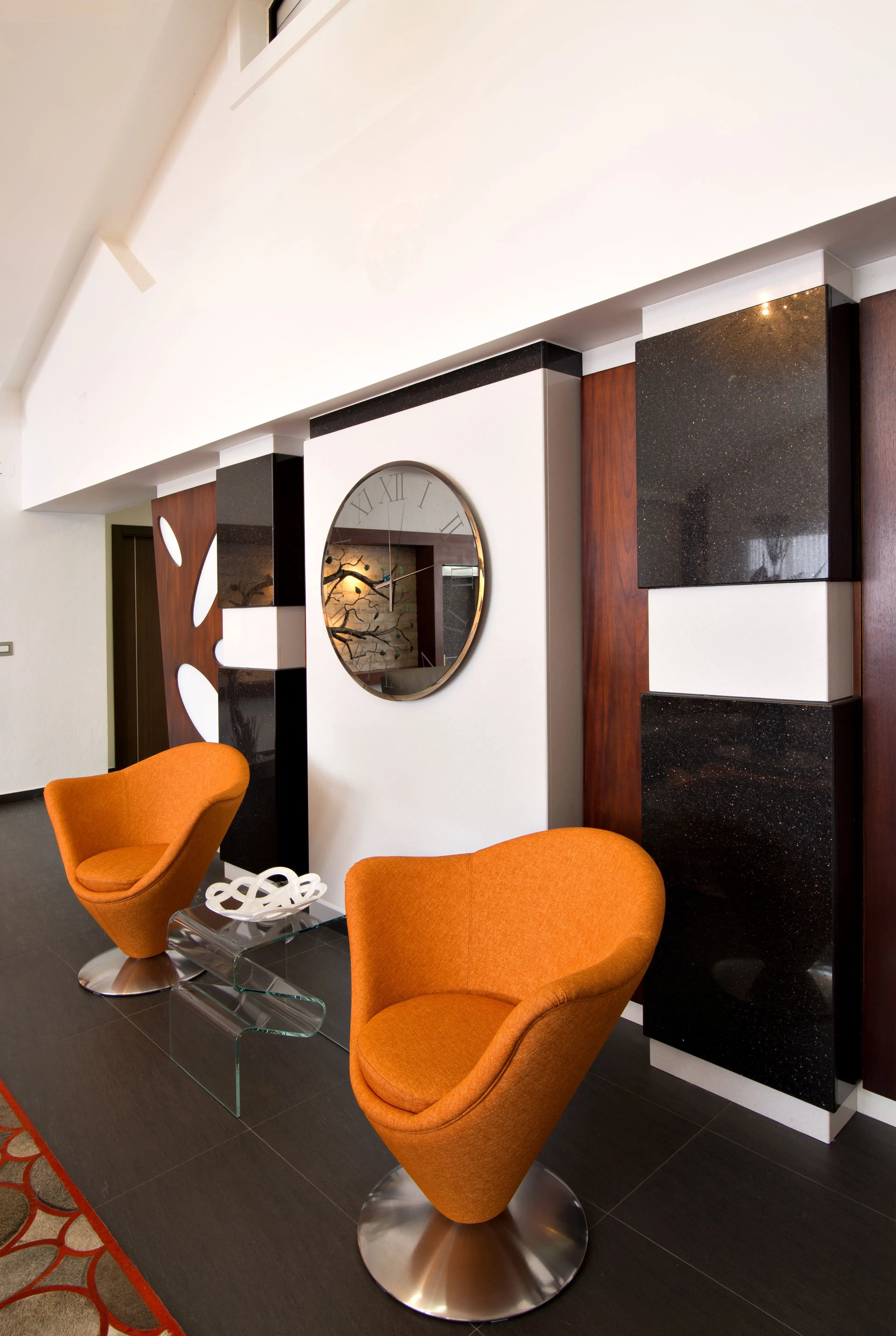 2 orange armchairs with round mirror and crystal table