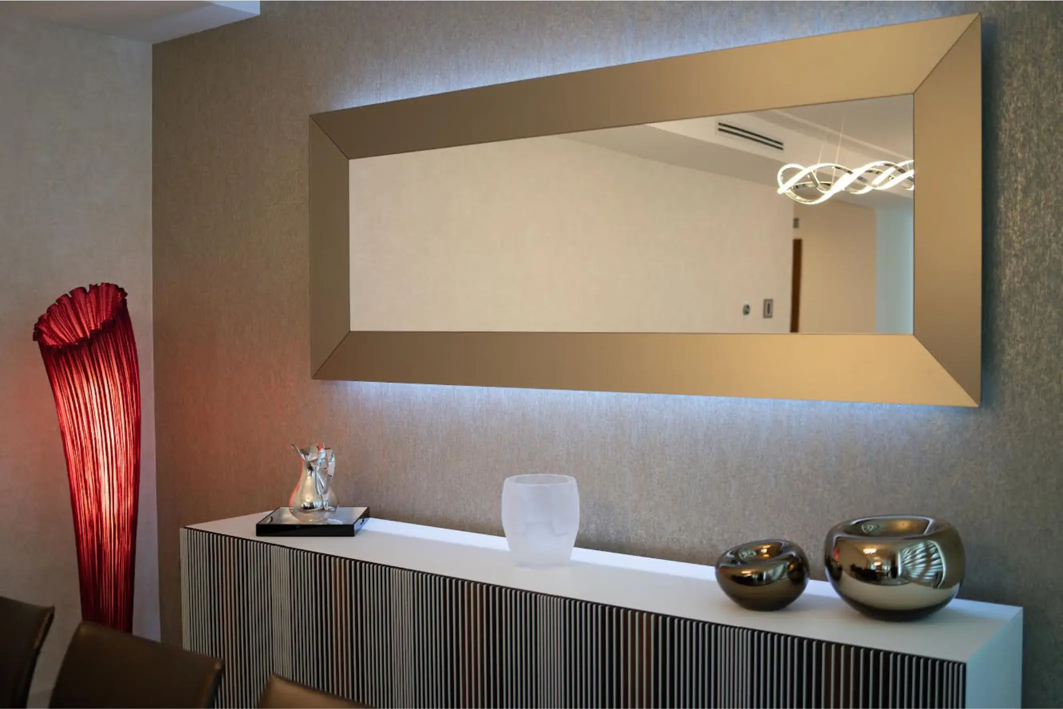 Golden mirror with illuminated red sculpture