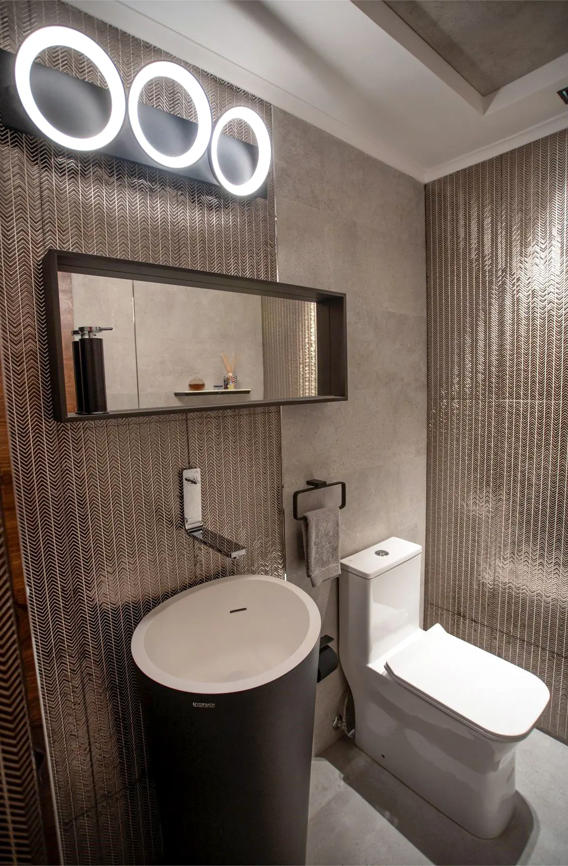 Black sink with mirror and 3 round lamps and toilet